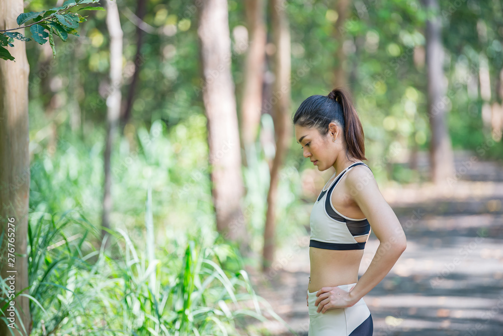 Asian sporty woman stretching body breathing fresh air in the park,Thailand people,Fitness and exercise concept,Jogging in the park Asian sporty woman stretching body breathing fresh air in the park,Thailand people,Fitness and exercise concept,Jogging in the park