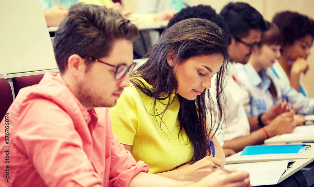 education, high school, university, learning and people concept - group of international students with notebooks writing at lecture education, high school, university, learning and people concept - group of international students with notebooks writing at lecture