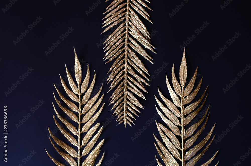 Naklejka premium Golden branches of tropical plants on a black background.