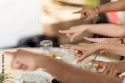 gesture and people concept - many hands pointing finger to something at restaurant