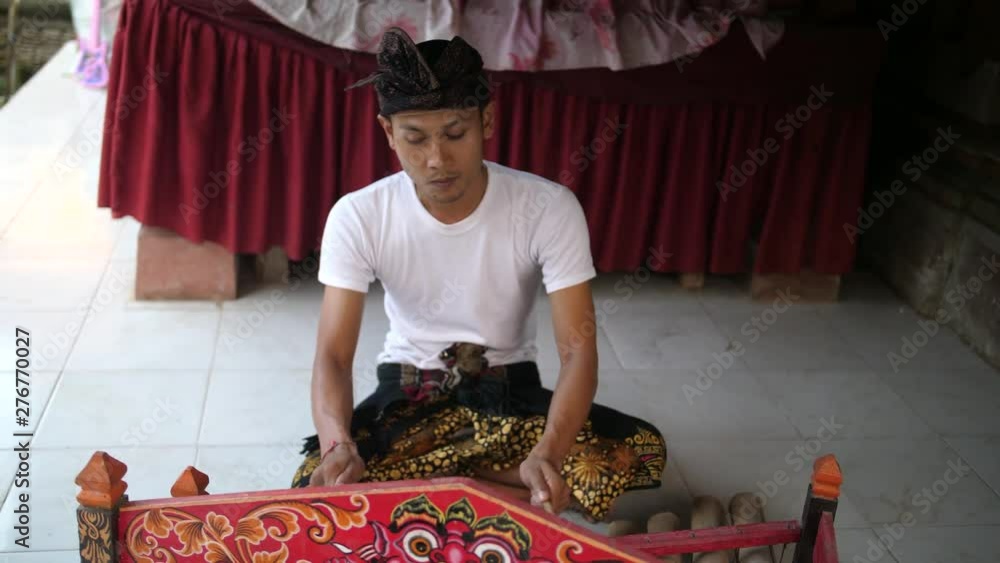 Man in Bali, Indonesia playing a tingklik, a traditional Balinese