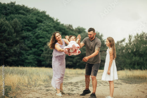 Happy family with two children has fun and laughs on a walk.