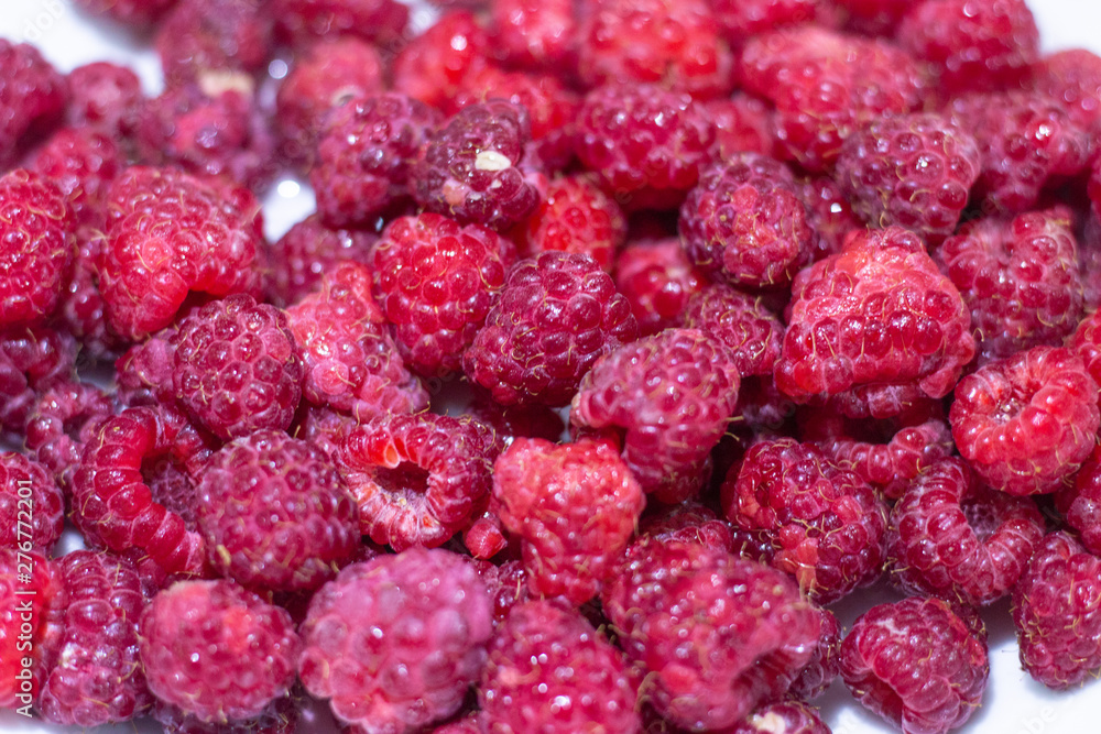 Red Raspberries in a square wooden pint container full isolated on white. Red raspberries in a white container. Red raspberry close-up Red Raspberries in a square wooden pint container full isolated on white. Red raspberries in a white container. Red raspberry close-up