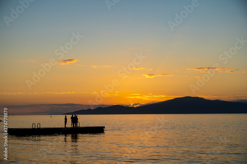 People on a floating deck enjoying sunset in the ocean