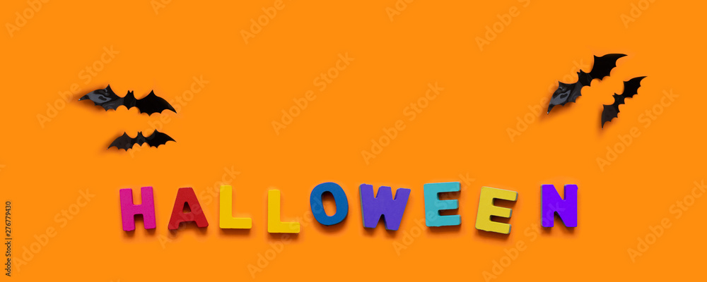  reative concept. Black bats and colorful inscription of wooden letters on orange background