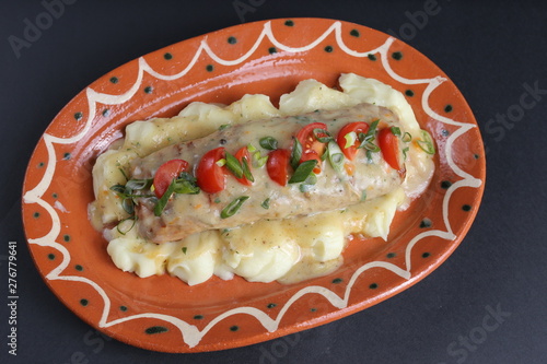 Cheesse souce, and chicken roll with tomato and onion on black background.