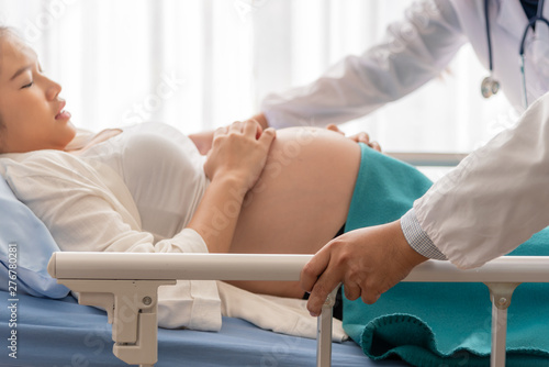 Blurred soft images of pregnant woman is suffering Because close to the brith, lying in a patient bed with a doctor help push the bed, To bring to the deliver room, to maternity and health concept.