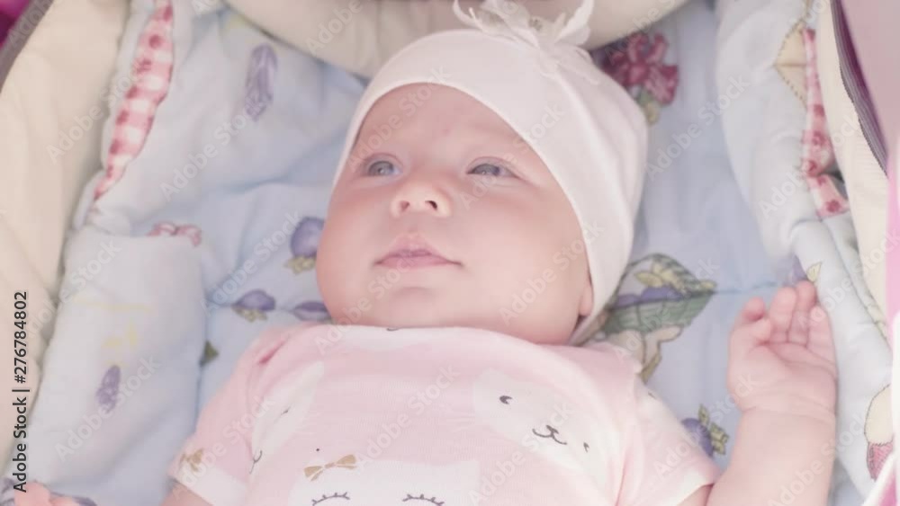 Infant baby lying  in stroller outdoors in summertime