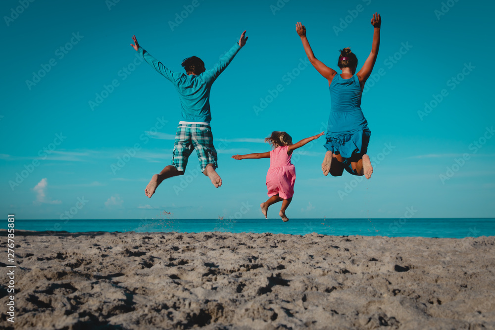 happy family- mom, dad and little daughter- jumping on beach happy family- mom, dad and little daughter- jumping on beach