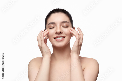 Smiling woman smearing cream on face