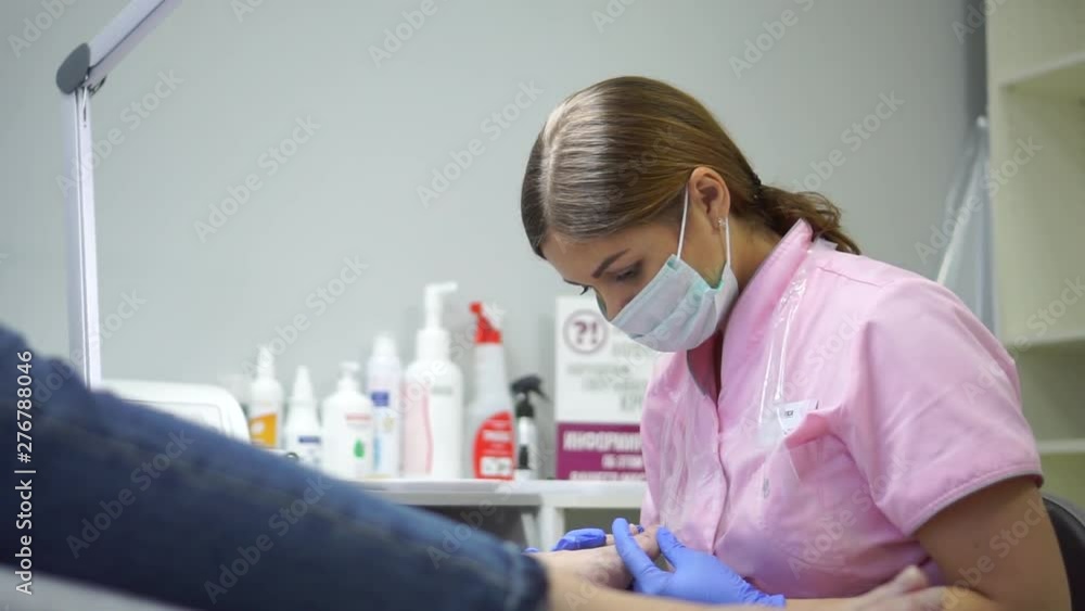 The girl in the center of the hardware pedicure do the procedure. The girl in the center of the hardware pedicure do the procedure.