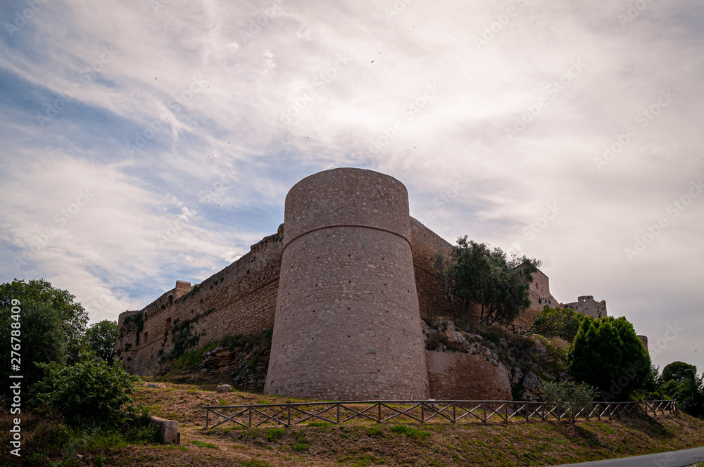 Magliano, Grosseto, Tuscany. Imposing tower of the city walls with a tower that defends the medieval town. The walls were built in the year 1000 by the Aldobrandeschi. Sky with white clouds