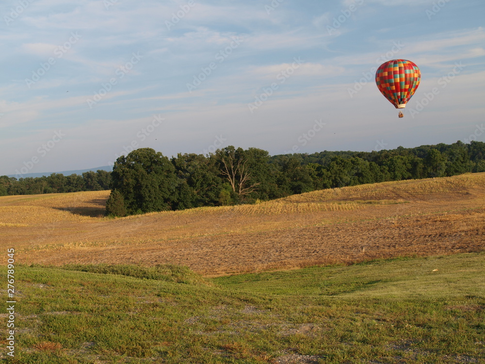 Obraz premium Hot Air Balloon Aloft Over Farm Fields