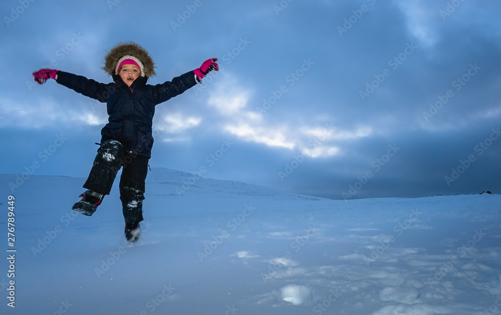 Happy little girl jumping in the snow Happy little girl jumping in the snow