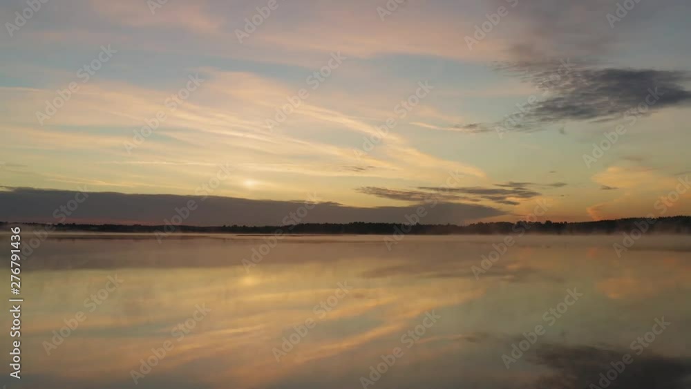 Drone shot moving forward over a lake during sunrise with morning mist Drone shot moving forward over a lake during sunrise with morning mist