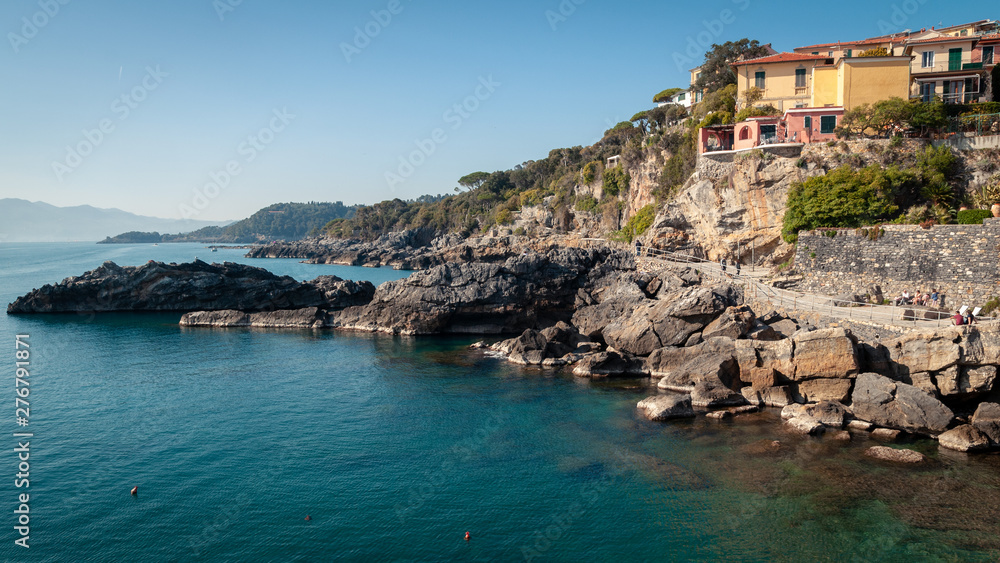 Tellaro, La Spezia, Italy. Typical Ligurian maritime glimpse: houses leaning against each other with the typical colors of Liguria above the cliff. Turquoise blue sea