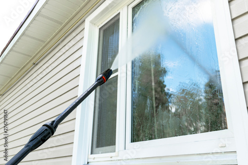 Cleaning service washing building facade and window with pressure water. Cleaning dirty wall with high pressure water jet. Power washing the wall. Cleaning the facade of the house. Before and after 