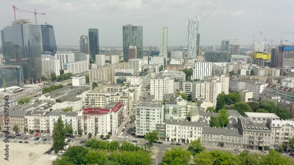 Aerial shot of the Warsaw skyline on a cloudy summer day. Drone on flight over residential buildings in the direction of skyscrapers in the business center of Warsaw. Shot on Drone 4K. Aerial shot of the Warsaw skyline on a cloudy summer day. Drone on flight over residential buildings in the direction of skyscrapers in the business center of Warsaw. Shot on Drone 4K.