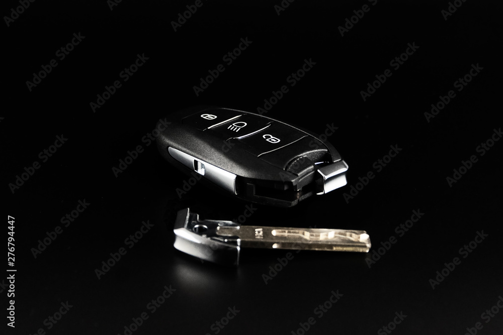 Modern car keys isolated on a black background with copy space for text or design elements. Car key with remote alarm. Modern car keys isolated on a black background with copy space for text or design elements. Car key with remote alarm.