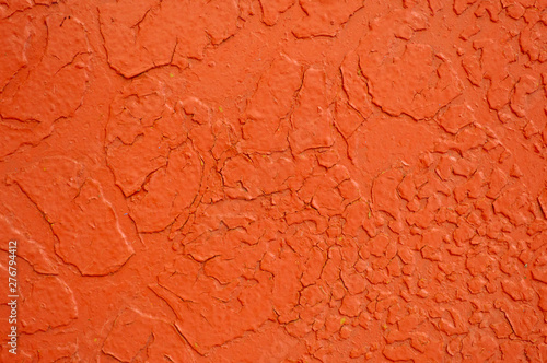 Texture of iron metal painted bright orange with peeling paint of old battered scratched cracked ancient rusty metal sheet wall with corrosion. The background