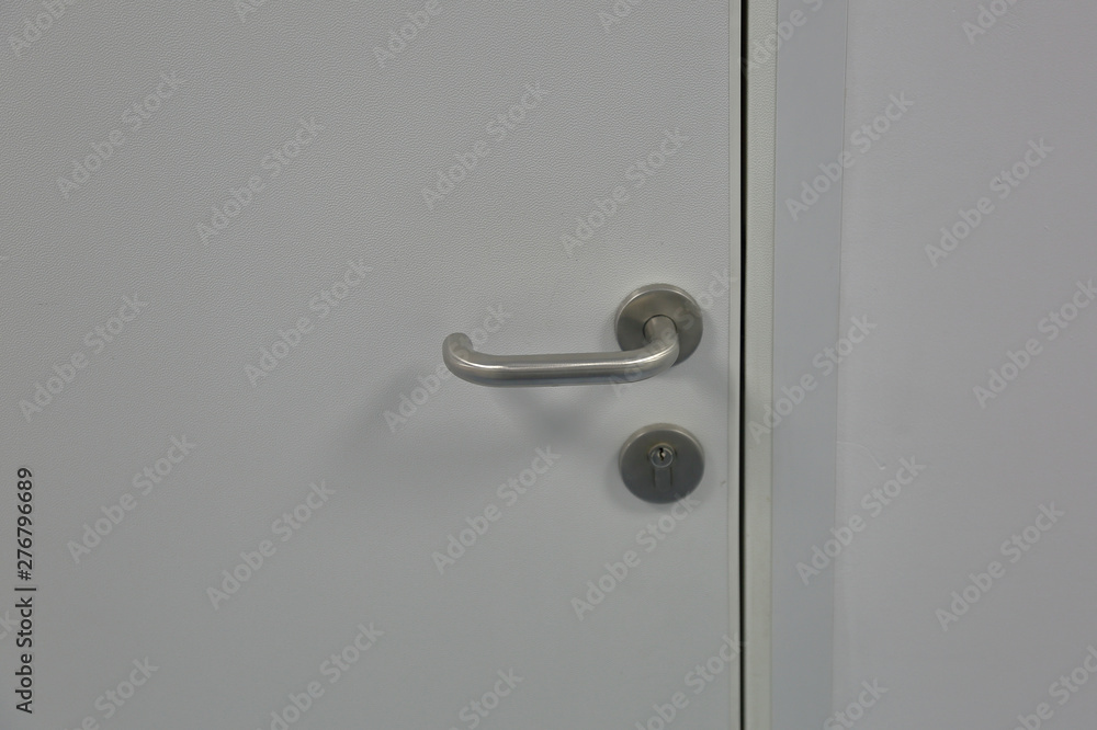 Minimalistic design of the door handle in metallic color on a gray background Minimalistic design of the door handle in metallic color on a gray background