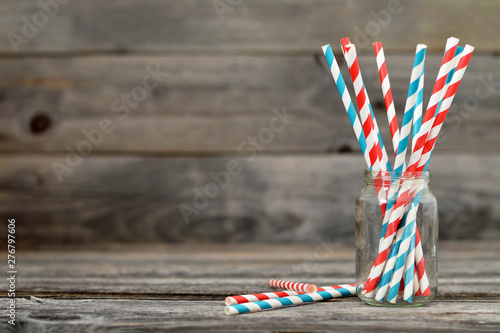 Paper straws in jar on wooden background with copy space