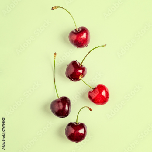 Cherry fruits composition on green background.
