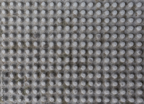Close-up of a weathered and faded rubber mat with knobs. Abstract high resolution full frame textured background.