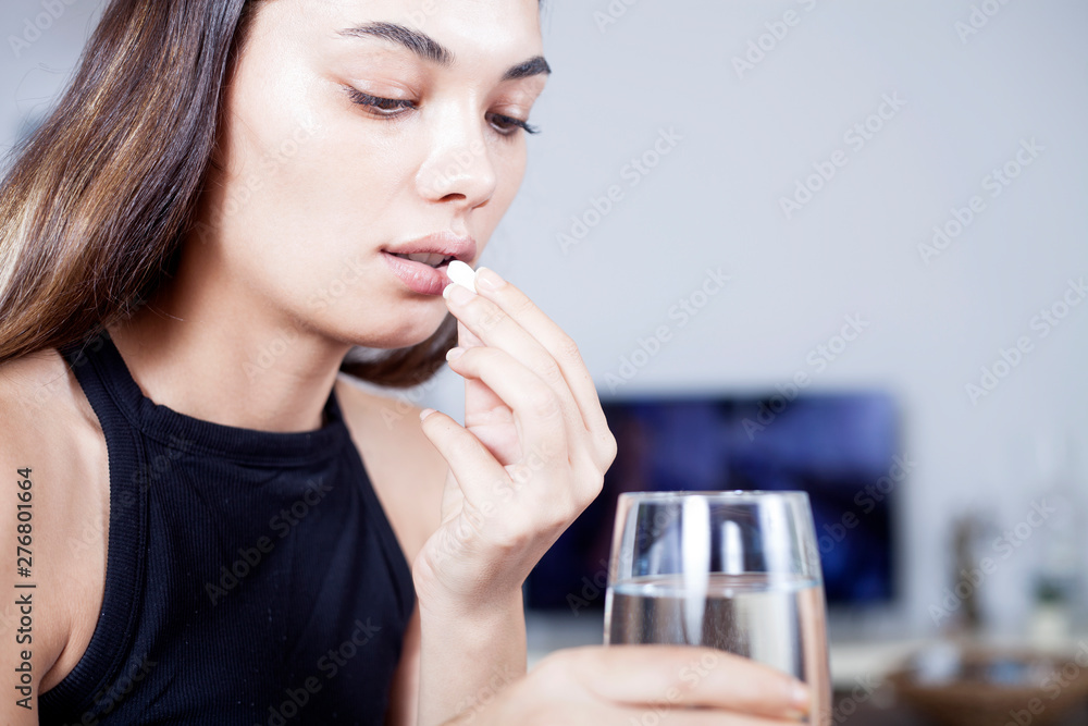 young woman taking medicine pill with water young woman taking medicine pill with water