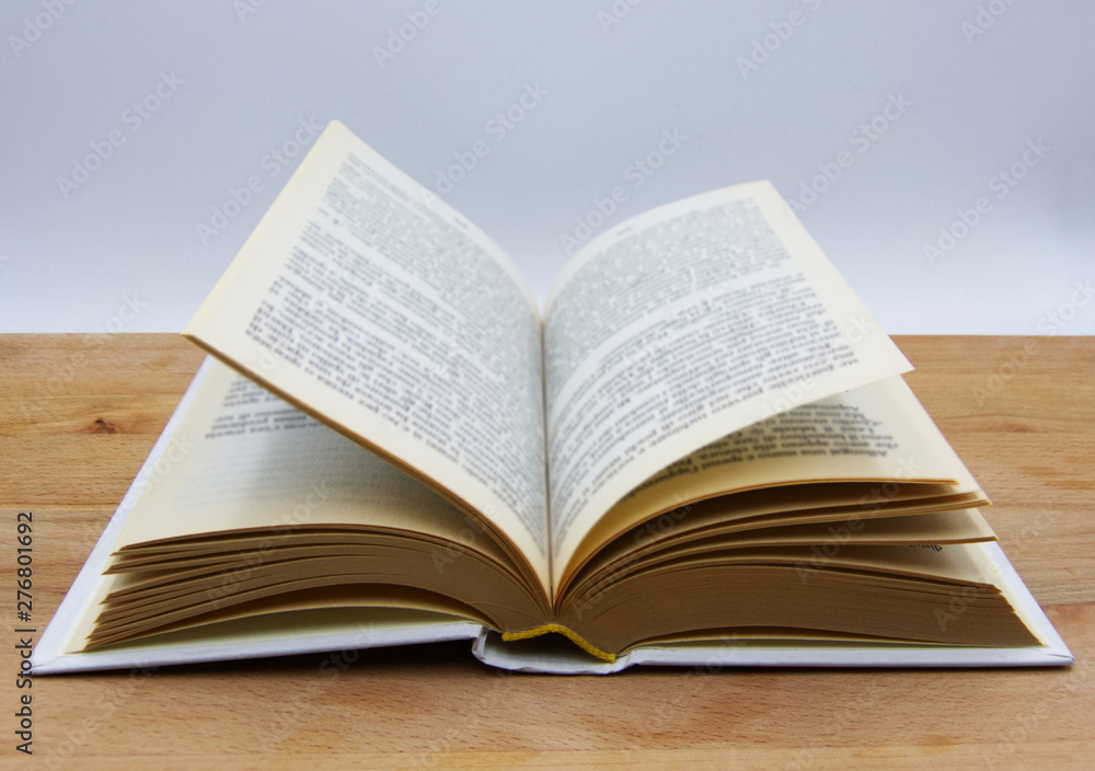 Open book on wooden table, white background Open book on wooden table, white background