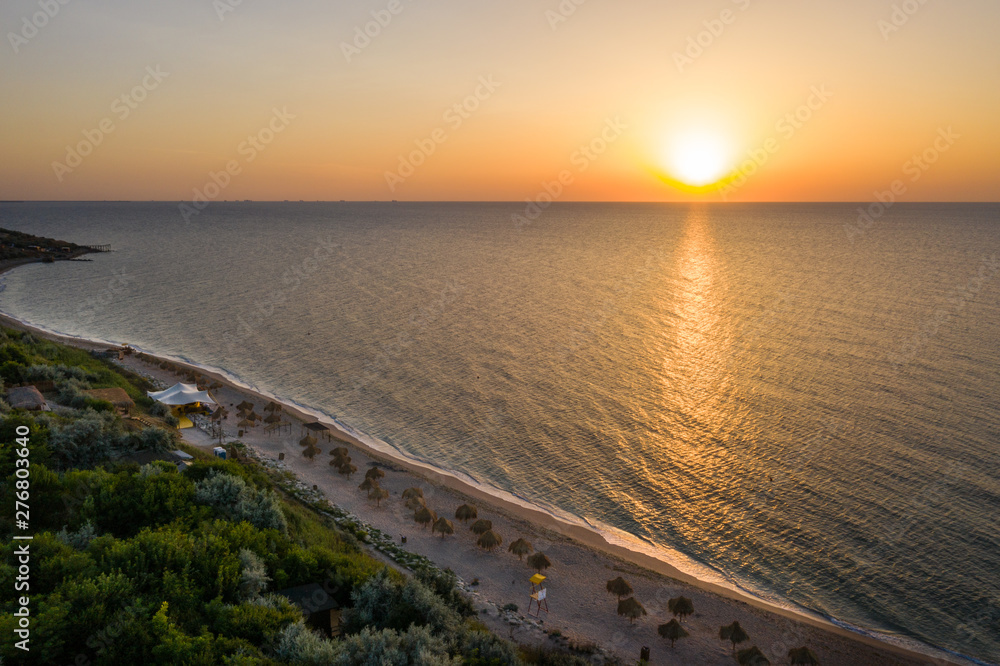 Sea sunrise early morning. Aerial View. Black Sea Sunset. Orange sky and low tide. Sea waves in the rays of a sunset. Sunset on the beach in summer season. Seascape. Sun over the skyline and sea waves
