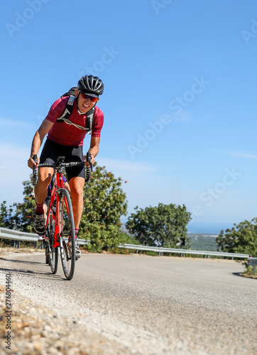 Fototapeta Naklejka Na Ścianę i Meble -  Young athletic man on a road bike cycling. 