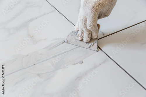 Obraz na płótnie Grouting tiles seams with a rubber trowel. w salonie