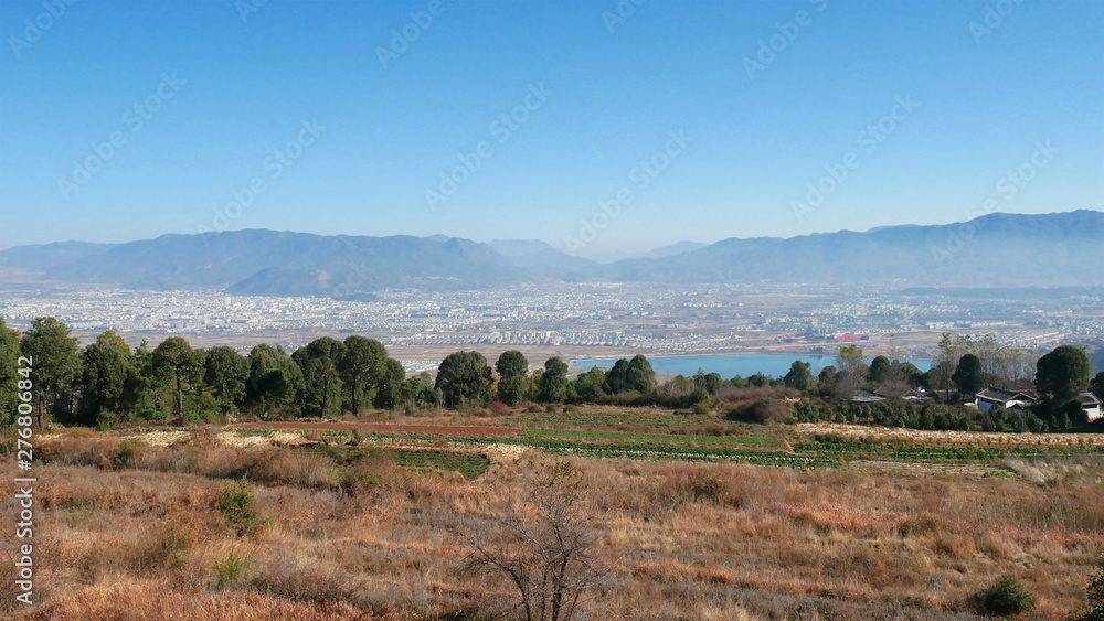 Landscape view with farmland and city of Lijiang on the background with mountain, Yunnan, China
