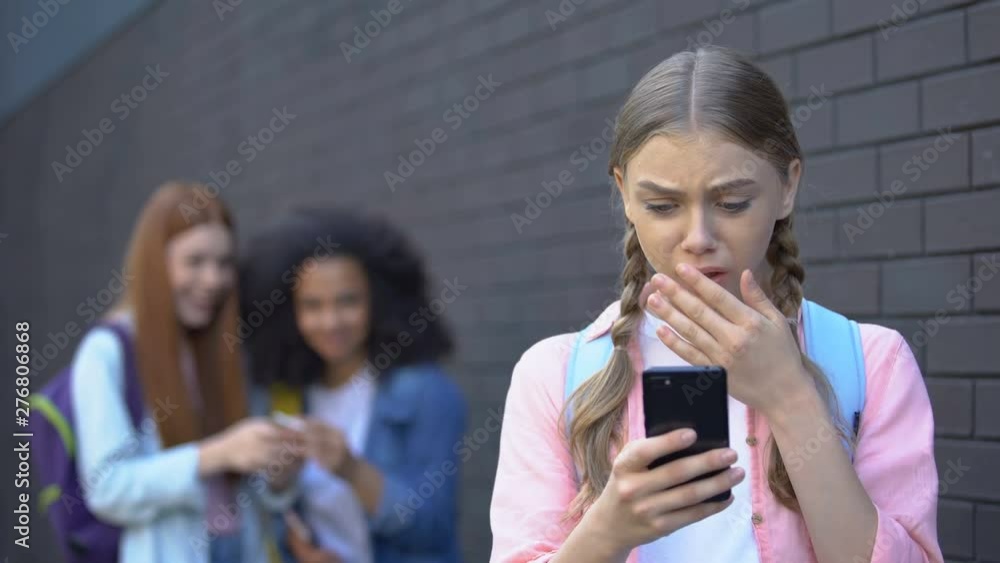 Embarrassed female teenager reading humiliating news in social networks, abuse Embarrassed female teenager reading humiliating news in social networks, abuse