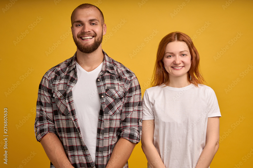 Head shot studio portrait smiling attractive millennial couple in love pose on yellow wall looking at camera, romantic relationships, young family wife and husband spouses, love and dating concept Head shot studio portrait smiling attractive millennial couple in love pose on yellow wall looking at camera, romantic relationships, young family wife and husband spouses, love and dating concept