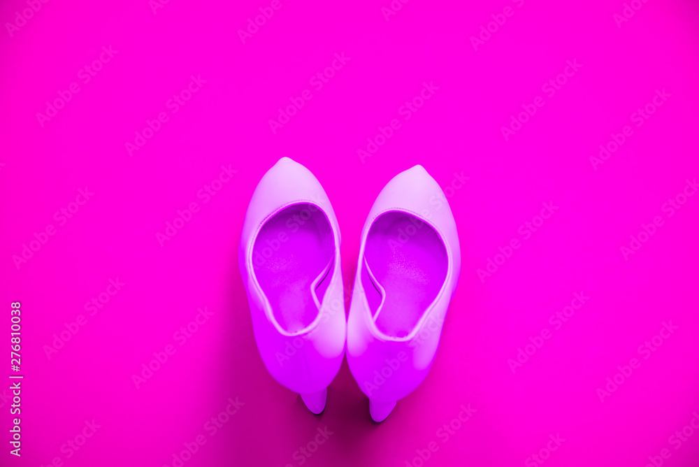 Pink high heeled shoes on pink purple background - top view - heels pointing up