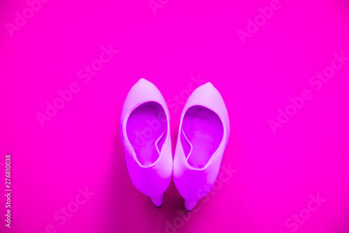 Pink high heeled shoes on pink purple background - top view - heels pointing up