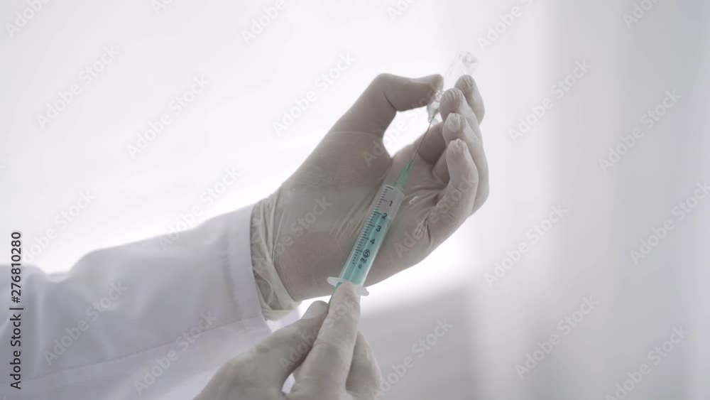 Doctor is filling medication into a syringe from vial for injection. 4K. Close up Doctor is filling medication into a syringe from vial for injection. 4K. Close up