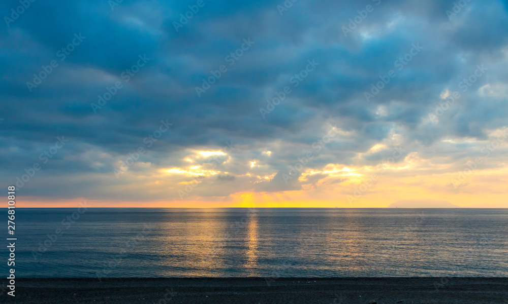 Fototapeta premium Picturesque sunset over Tyrrhenian Sea in Milazzo town, Sicily, Italy. Aeolian Islands (Italian: Isole Eolie), volcanic archipelago on the north of Sicily on the background