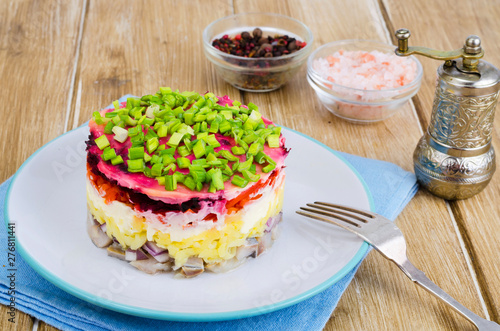 Layered salad with vegetables and herring.