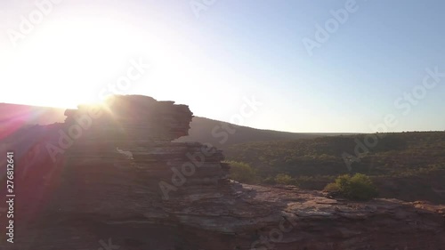the natural window in the barren desert of the Kalbarri National Park offers a wonderful view of the valley illuminated by the red sun