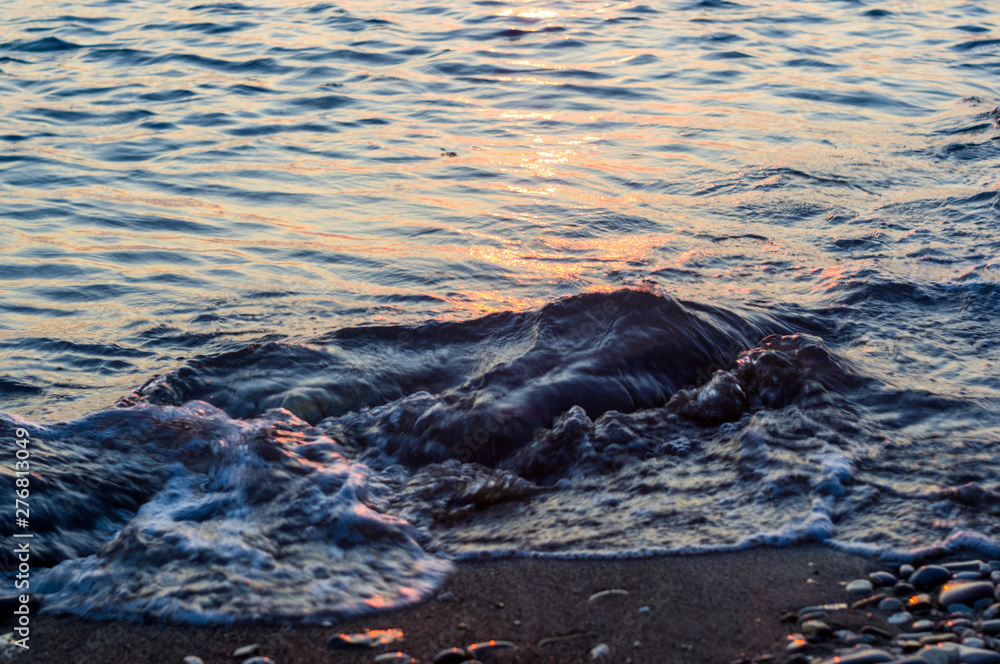 Obraz premium pebble stones on the sea beach, the rolling waves of the sea with foam