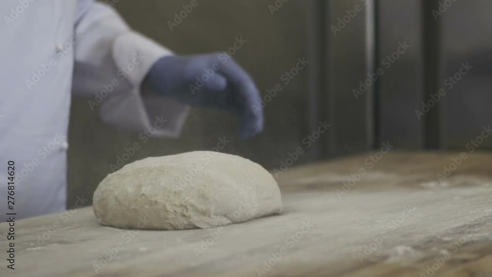 Chef kneading dough in flour on a table. Slow motion 100 fps Chef kneading dough in flour on a table. Slow motion 100 fps