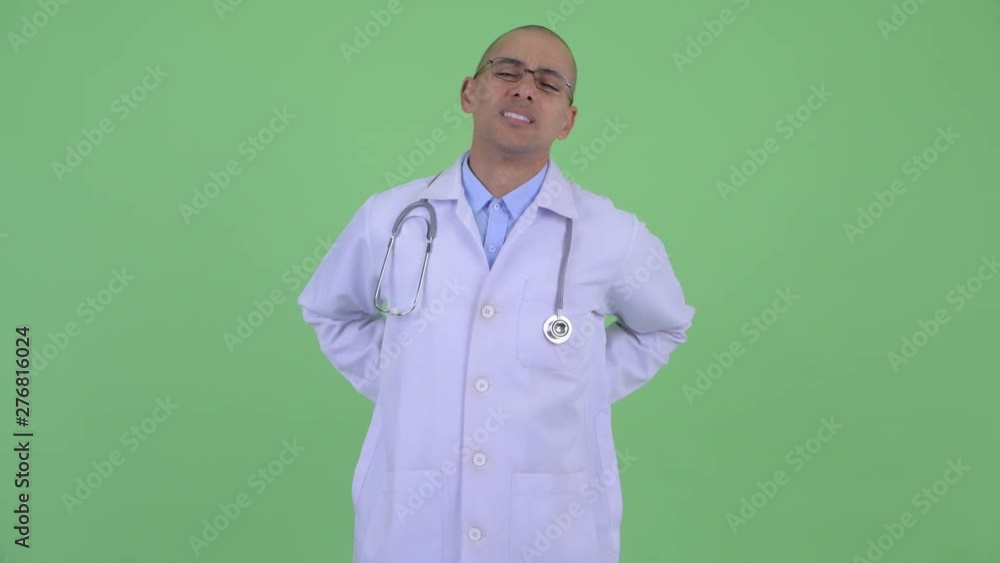 Stressed bald multi ethnic man doctor having back pain Stressed bald multi ethnic man doctor having back pain