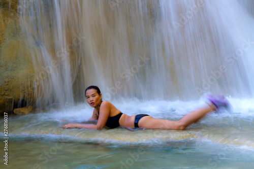 Woman in bikini black play water at Erawan Waterfall