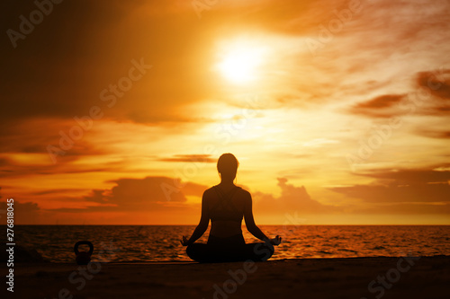 woman practicing yoga during surrealistic sunset at the seaside. healthy concept and workout. © Love You Stock