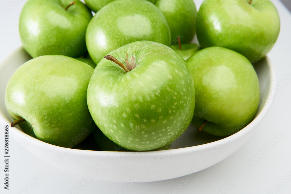 Green Granny Smith cooking apples in a white bowl close-up from above. Green Granny Smith cooking apples in a white bowl close-up from above.
