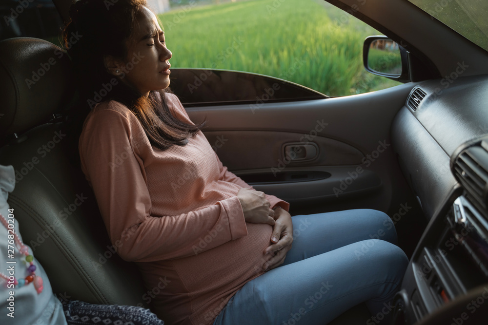pregnant woman belly ache during trip on car holding her tummy pregnant woman belly ache during trip on car holding her tummy