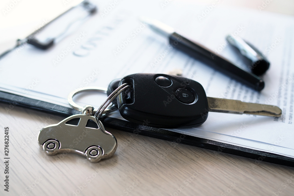 Car keys placed on contract documents about car loans. Car keys placed on contract documents about car loans.